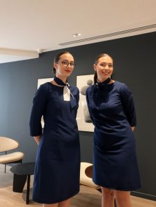 agence hôtesse Paris hôtesses professionnelles en uniforme bleu marine, souriantes, dans un décor intérieur moderne, prêtes à représenter votre marque.